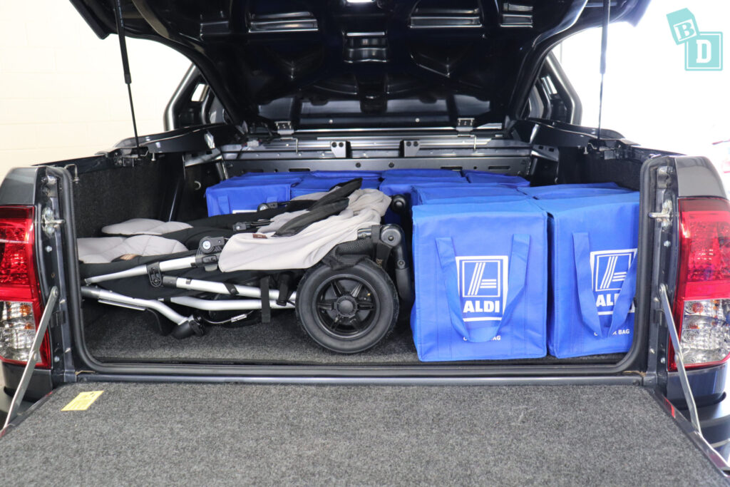 The 2023 Toyota HiLux Rogue truck is filled with blue bags and a twin pram