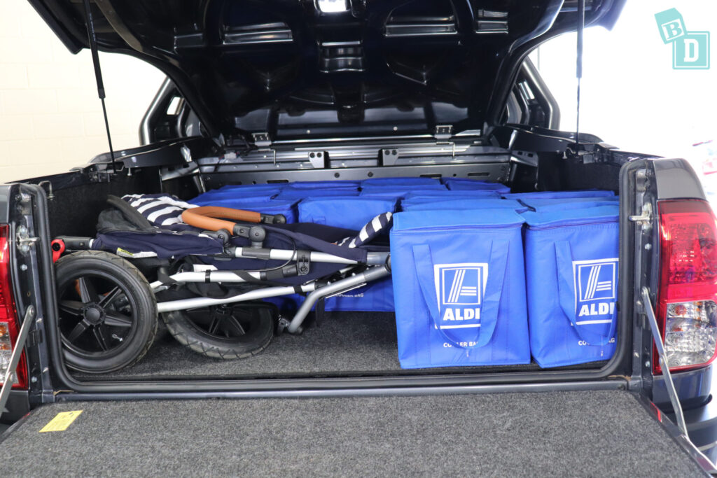 The 2023 Toyota HiLux Rogue truck is filled with blue bags and a pram