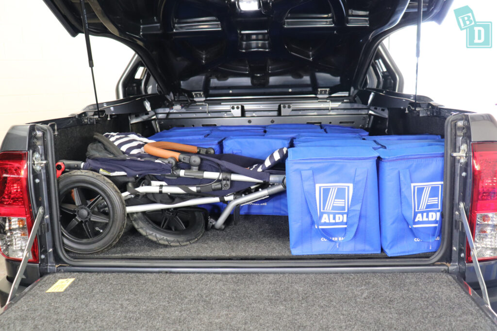 The 2023 Toyota HiLux Rogue truck is filled with blue bags and a pram
