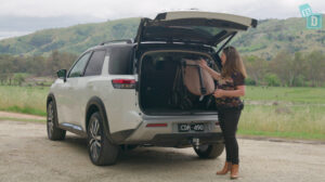 A woman opens the trunk of a 7 seater SUV.