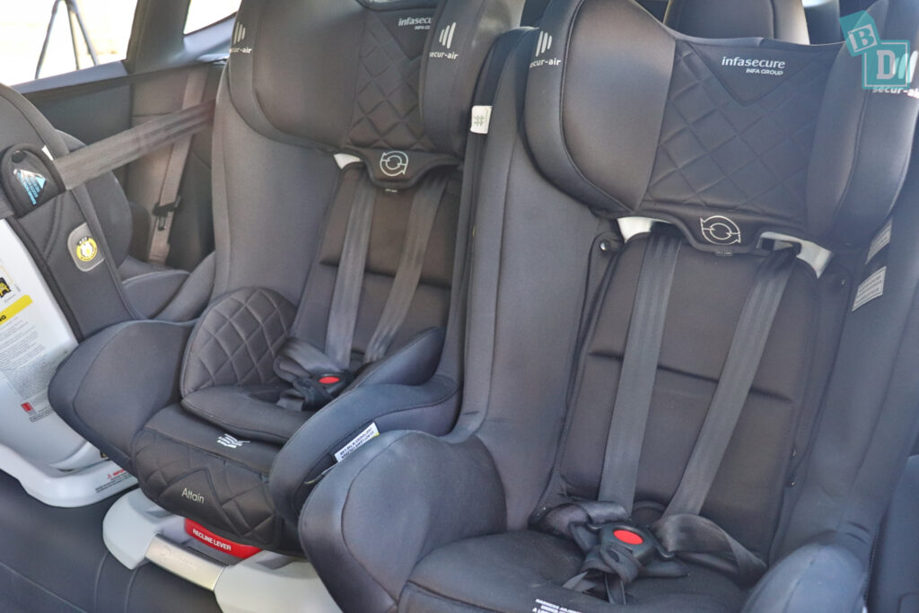 a 2023 Tesla Model Y with 3 child seats in the back seat.