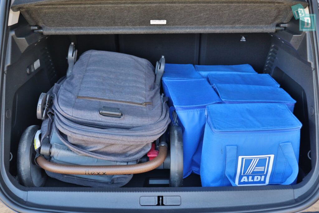 the trunk of a car is filled with blue bags and a baby stroller.