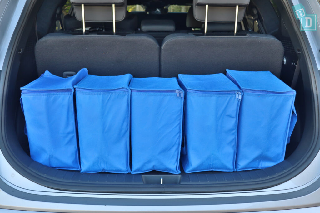 blue storage bags in the trunk of a 2023 Hyundai Santa Fe Hybrid with all three rows of seats in use