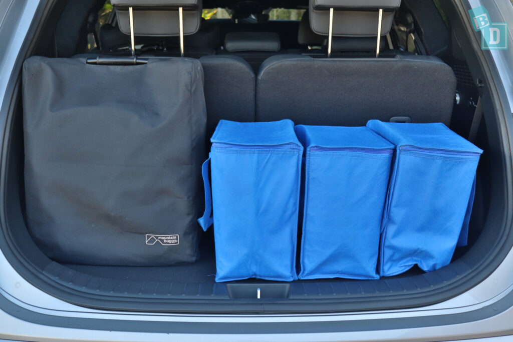 the trunk of a 2023 Hyundai Santa Fe Hybrid with compact stroller and blue bags