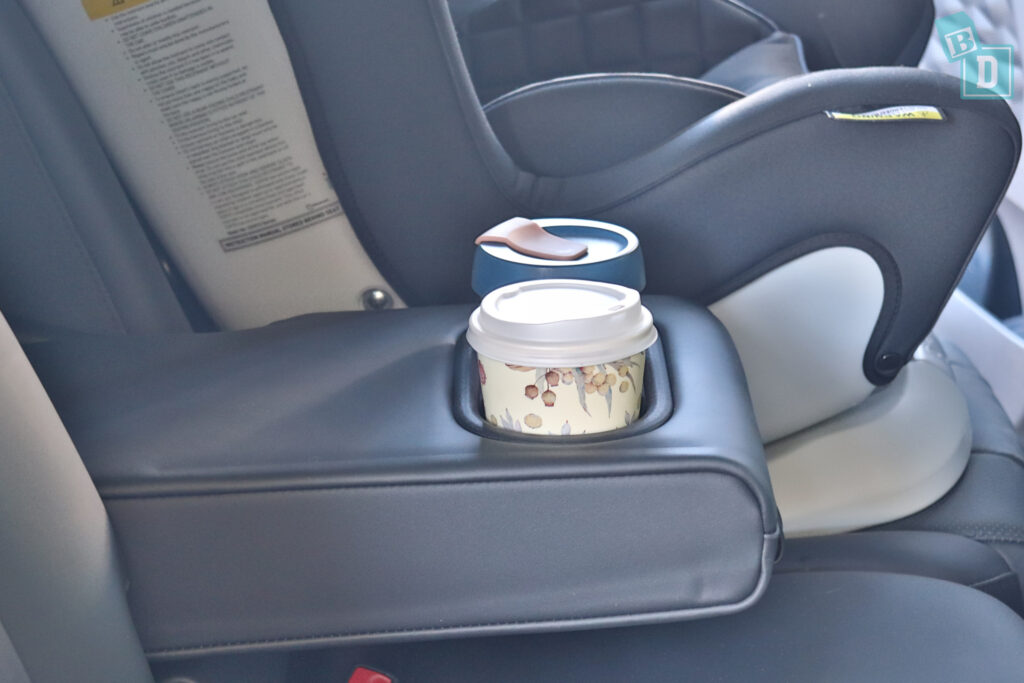 a car seat with a cup holder and a cup of coffee.