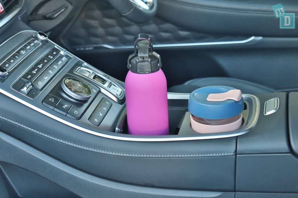 a car cup holder with a bottle in it.