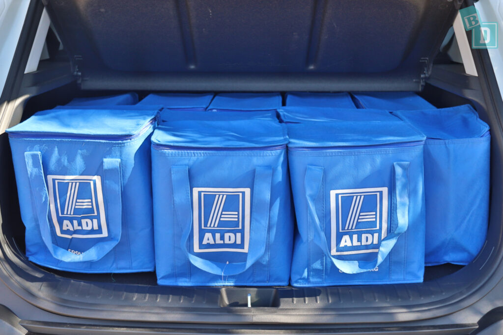 the trunk of a 2023 Kia Seltos is filled with blue bags.