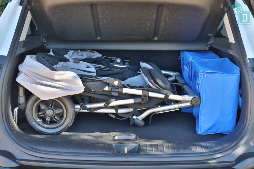 the trunk of a 2023 Kia Seltos with a twin side by side stroller in it.