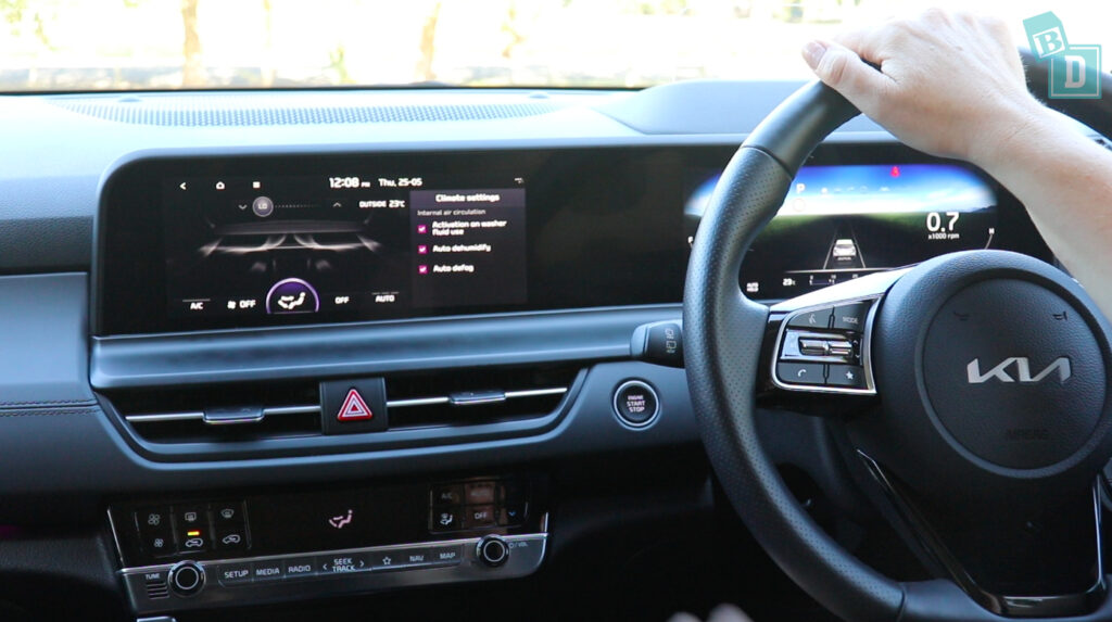 a person is driving a car with a touchscreen dashboard.