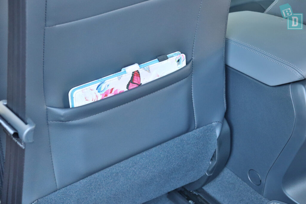 the back seat of a car has a magazine in it.