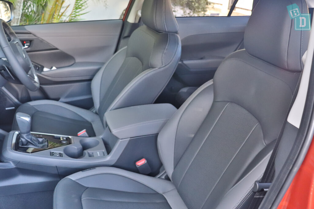 the interior of a red car with leather seats.