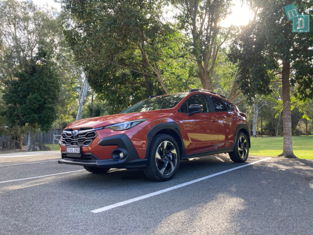 a red subaru rav4 parked in a parking lot.