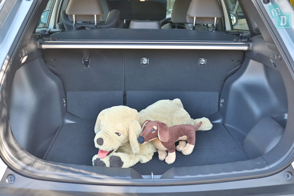 a teddy bear is sitting in the trunk of a 2023 Toyota Corolla Cross hybrid