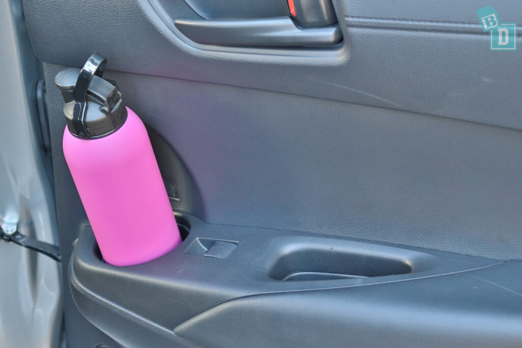 a pink water bottle is sitting in the back seat of a car.