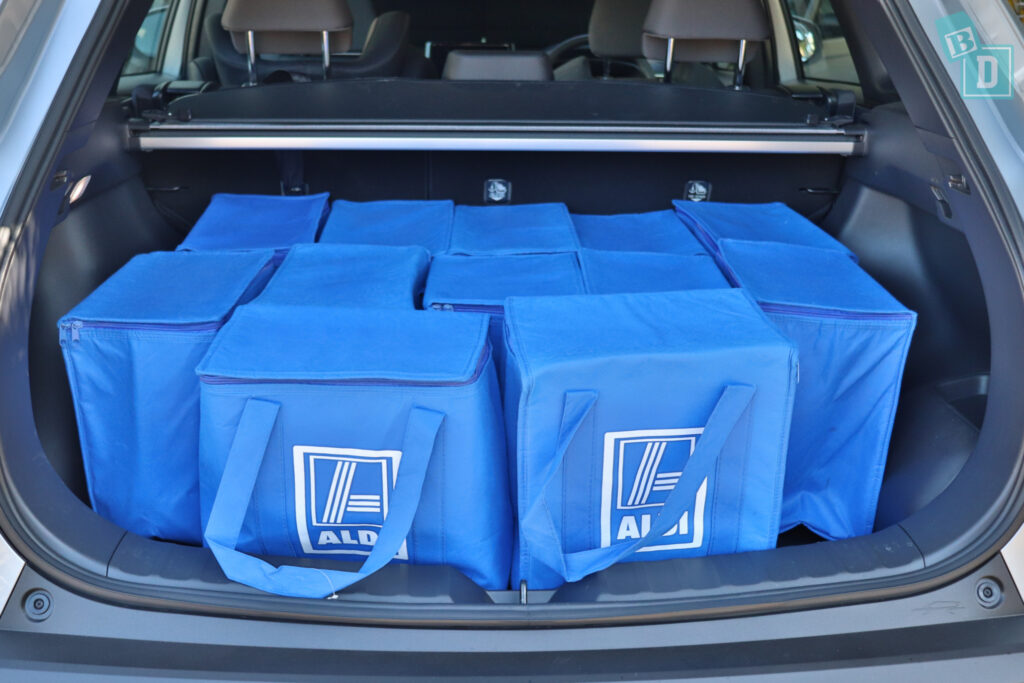 the trunk of a 2023 Toyota Corolla Cross hybrid is filled with blue bags.