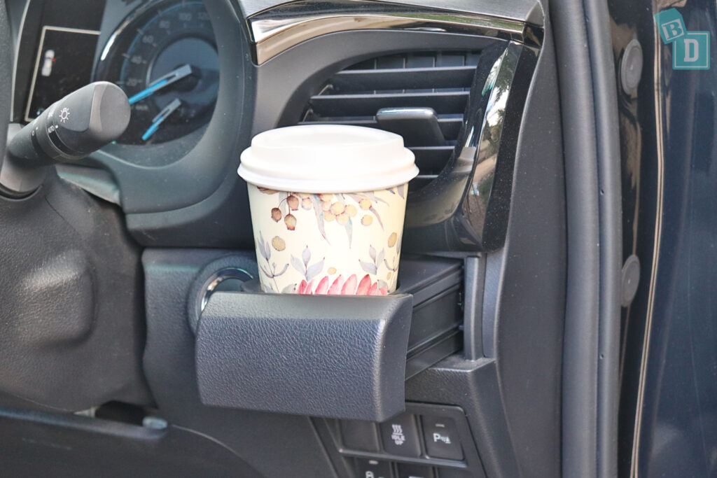 a cup of coffee in a cup holder in a car.