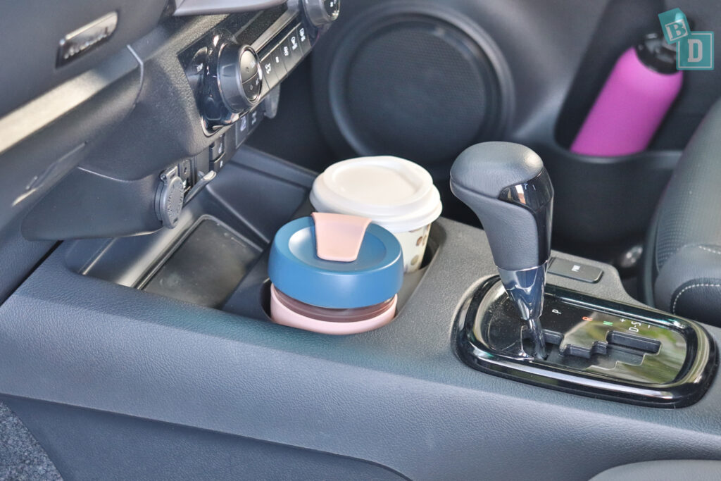 a cup holder in a car with a cup in it.