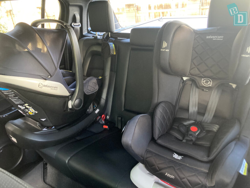 forward facing child seat and infant capsules in the back of a 2023 Toyota HiLux Rogue