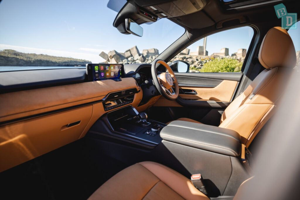 the interior of a suv with leather seats and a view of the city.