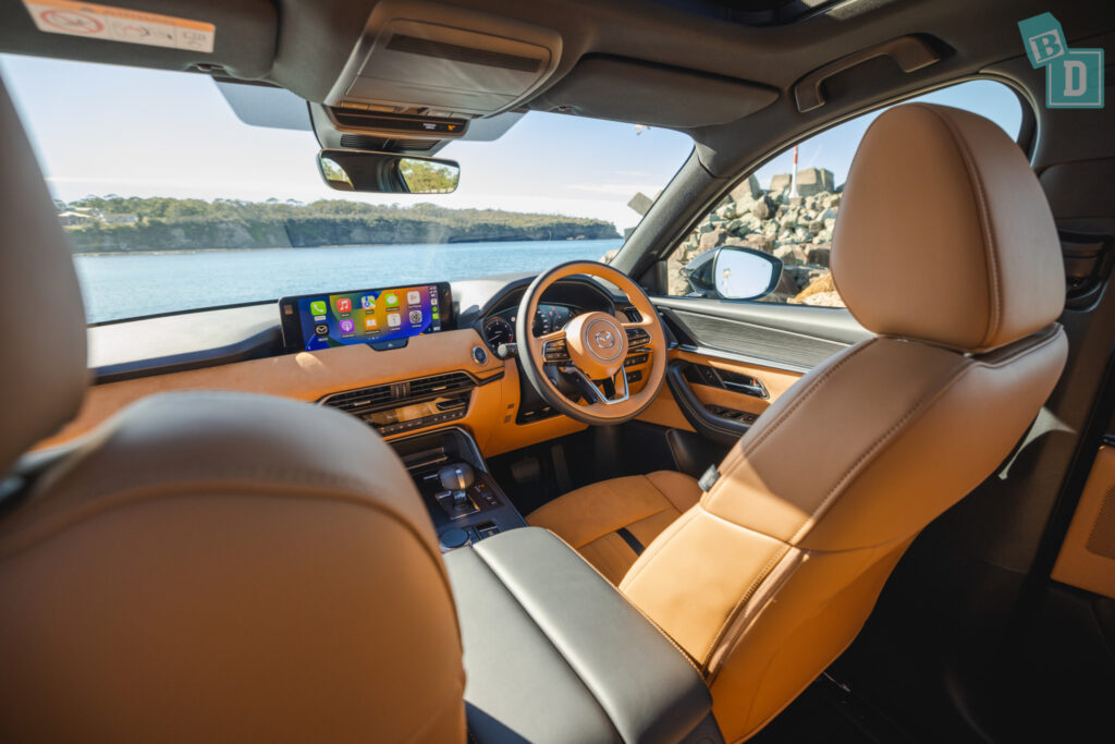 the interior of a suv with leather seats and a view of the ocean.