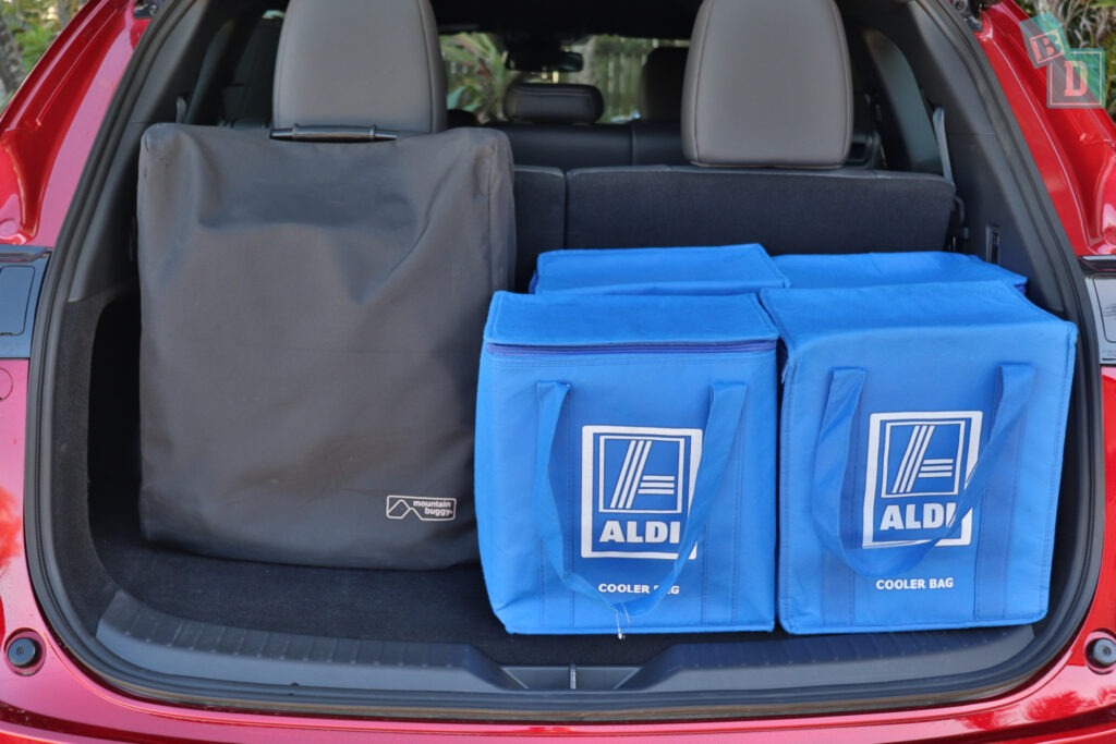 The trunk of a suv with blue bags in it.