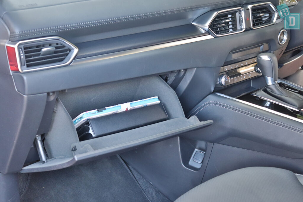 The center console of a car with a tablet in it.