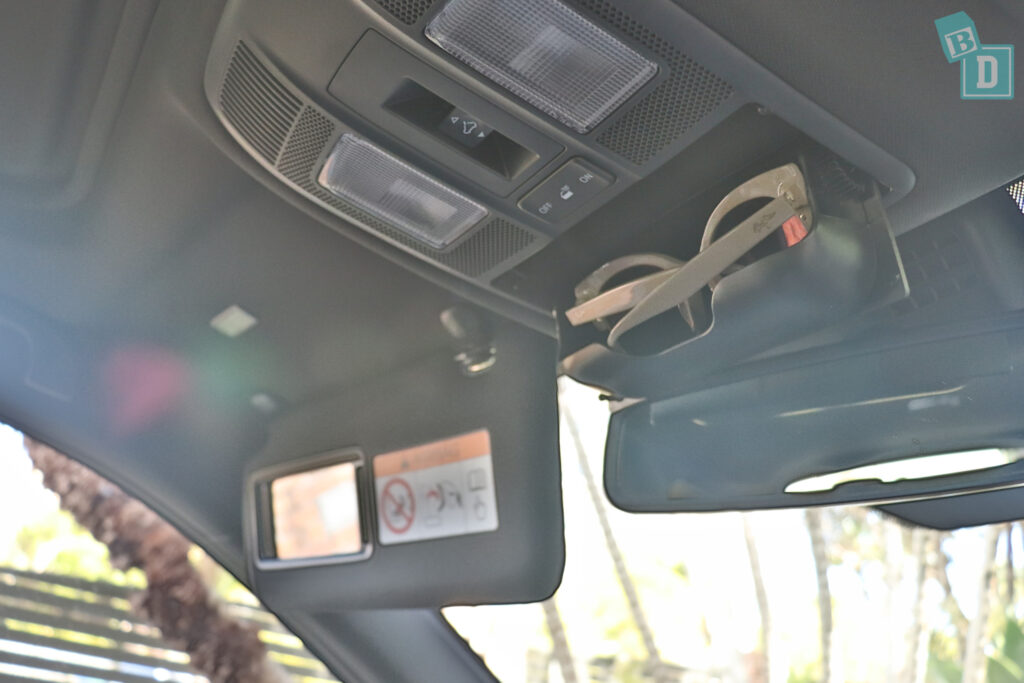 The rear view mirror of a car is shown with a pair of sunglasses.