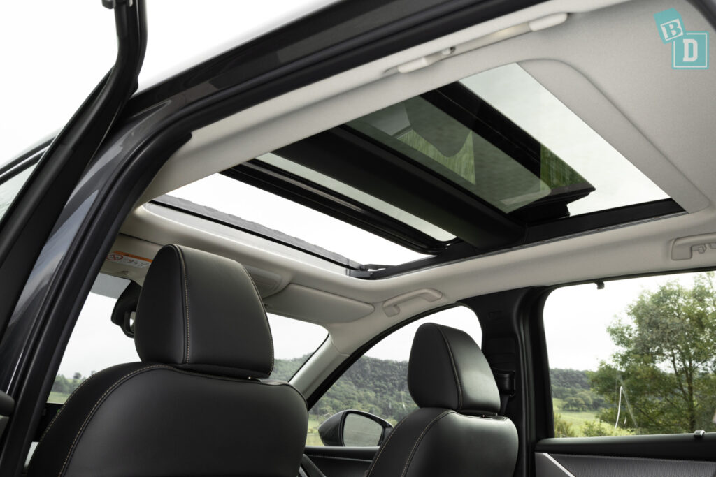 The sunroof of a 2023 Mazda CX-90 with black leather seats.