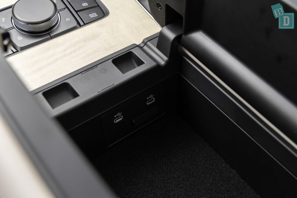 The center console of a car with a power outlet.