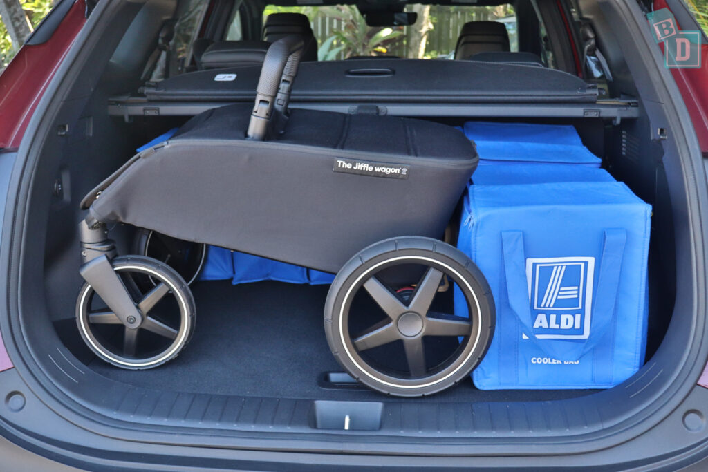 The trunk of a suv with a stroller in it.