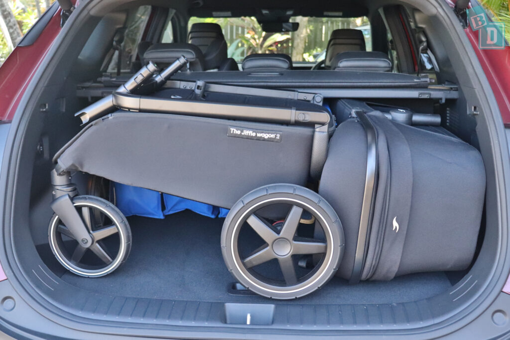 The trunk of a suv with a stroller in it.