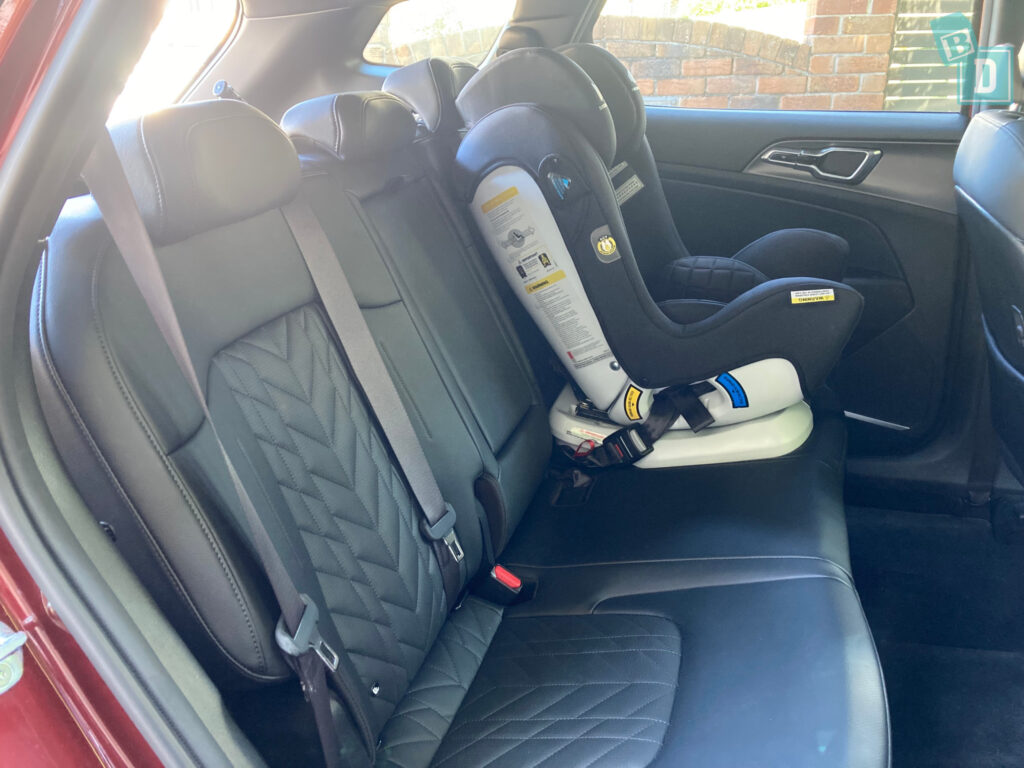 The back seat of a car with a baby car seat.