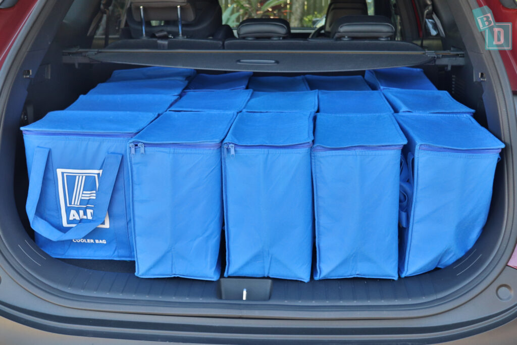The trunk of a car filled with blue bags.