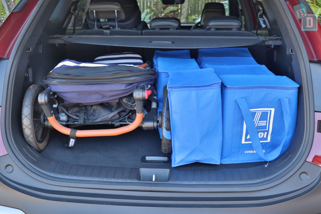 The trunk of a car is full of blue bags.