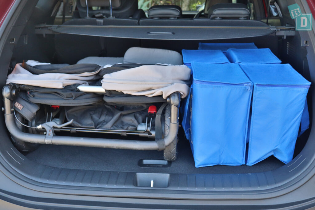 The trunk of a car is filled with blue bags.