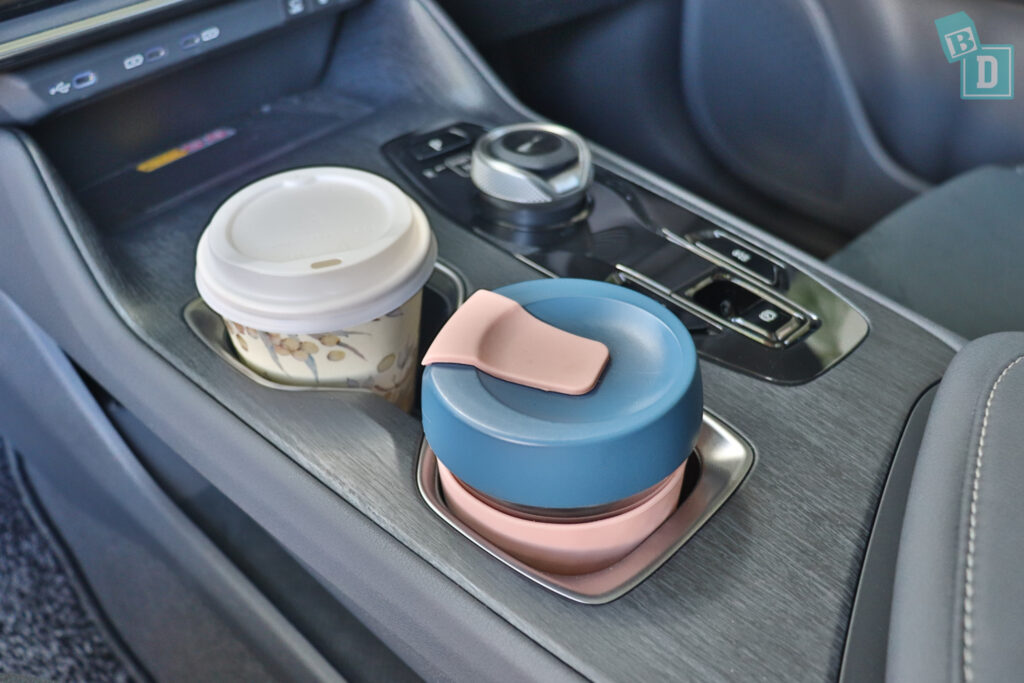 A cup of coffee is sitting in a cup holder in a car.