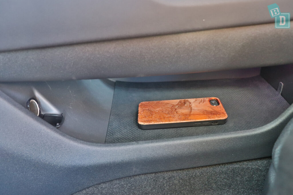 A cell phone is sitting in the center console of a car.