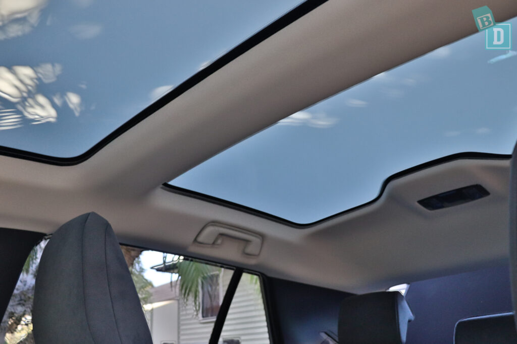 The sunroof of a car with a view of the sky.