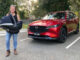 A woman standing next to a red 2023 Mazda CX-8 SUV, which has been released as the 2023 Mazda CX-8.