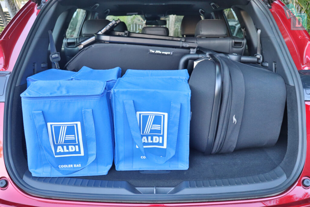 The trunk of a 2023 Mazda CX-8 with blue bags in it.