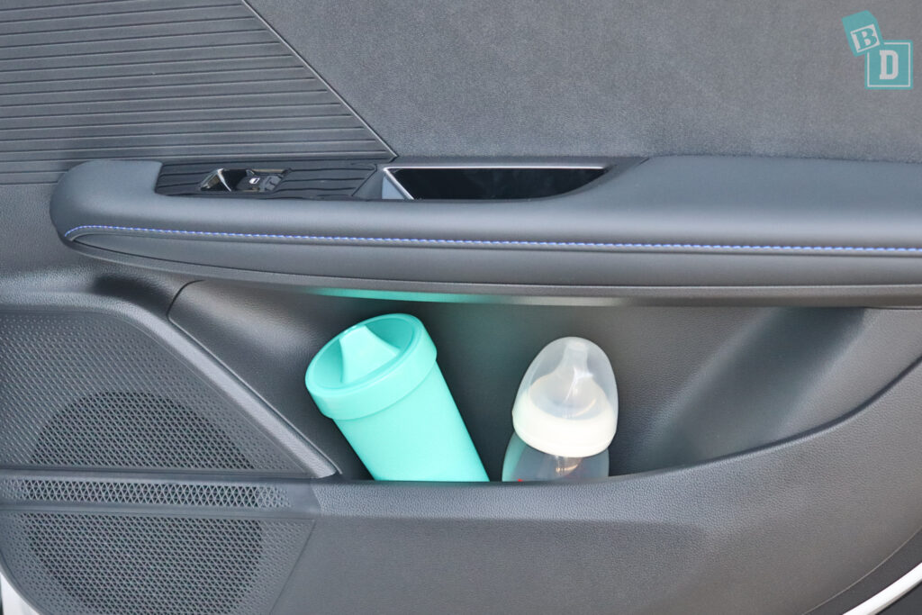 A car with a cup holder and a bottle in it.