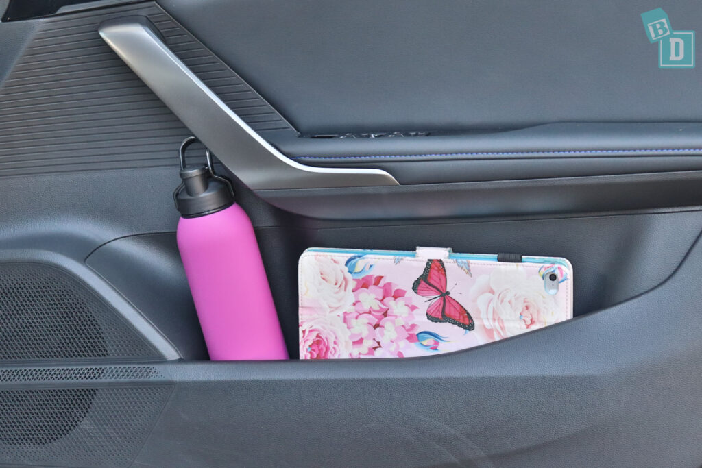 A car with a pink purse and a bottle in the back seat.