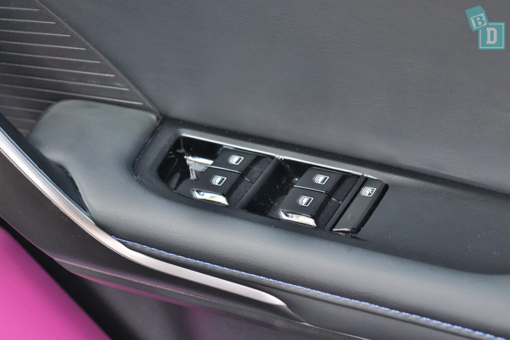 The interior of a car with a pink door handle.