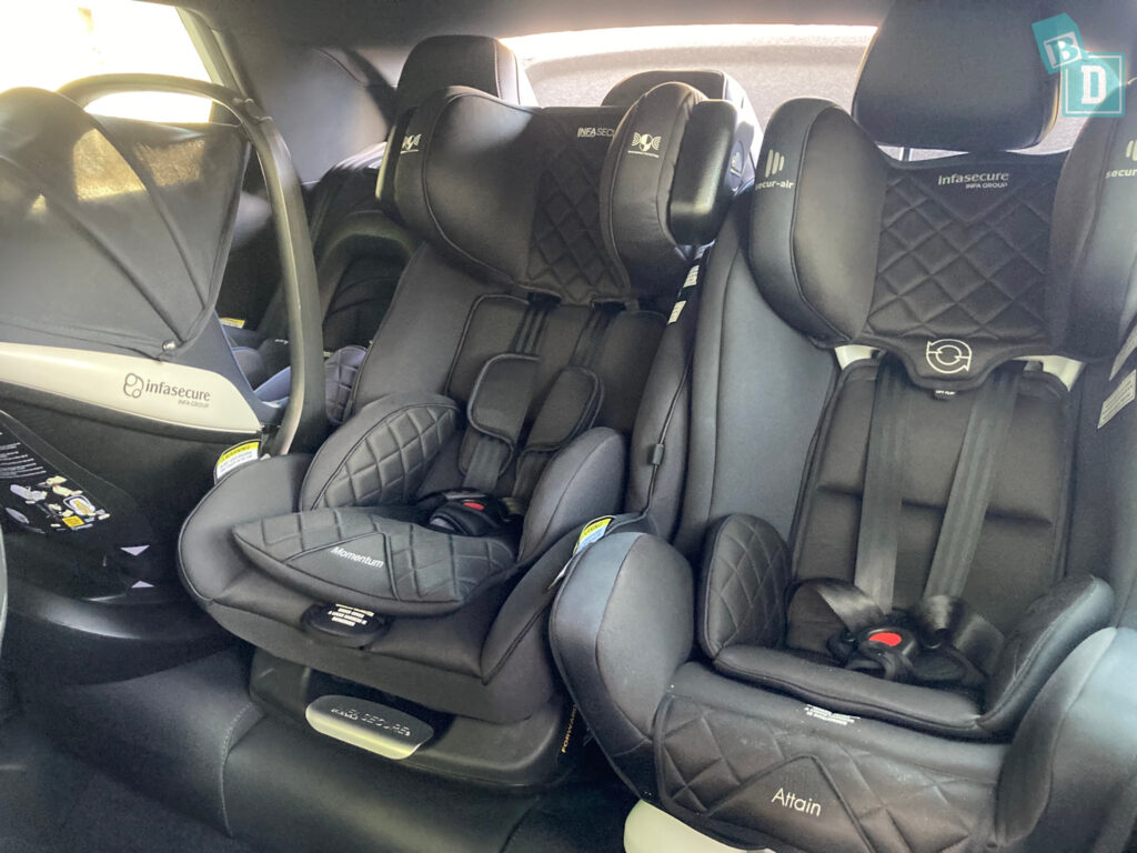 Two car seats in the back of a car.