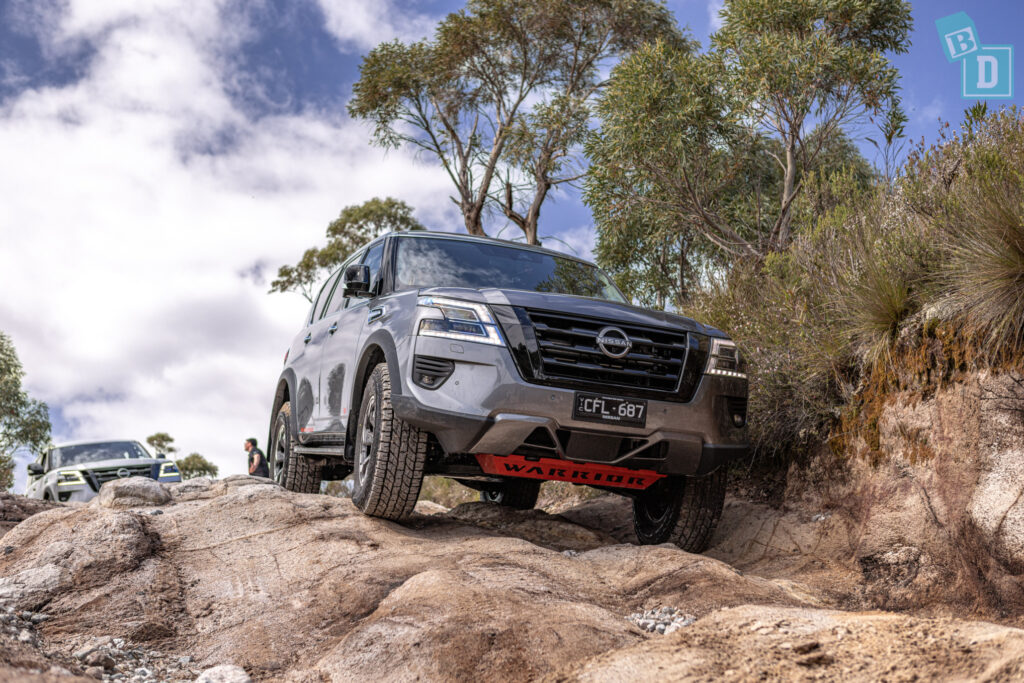 A 2023 Nissan Patrol is driving down a rocky trail.