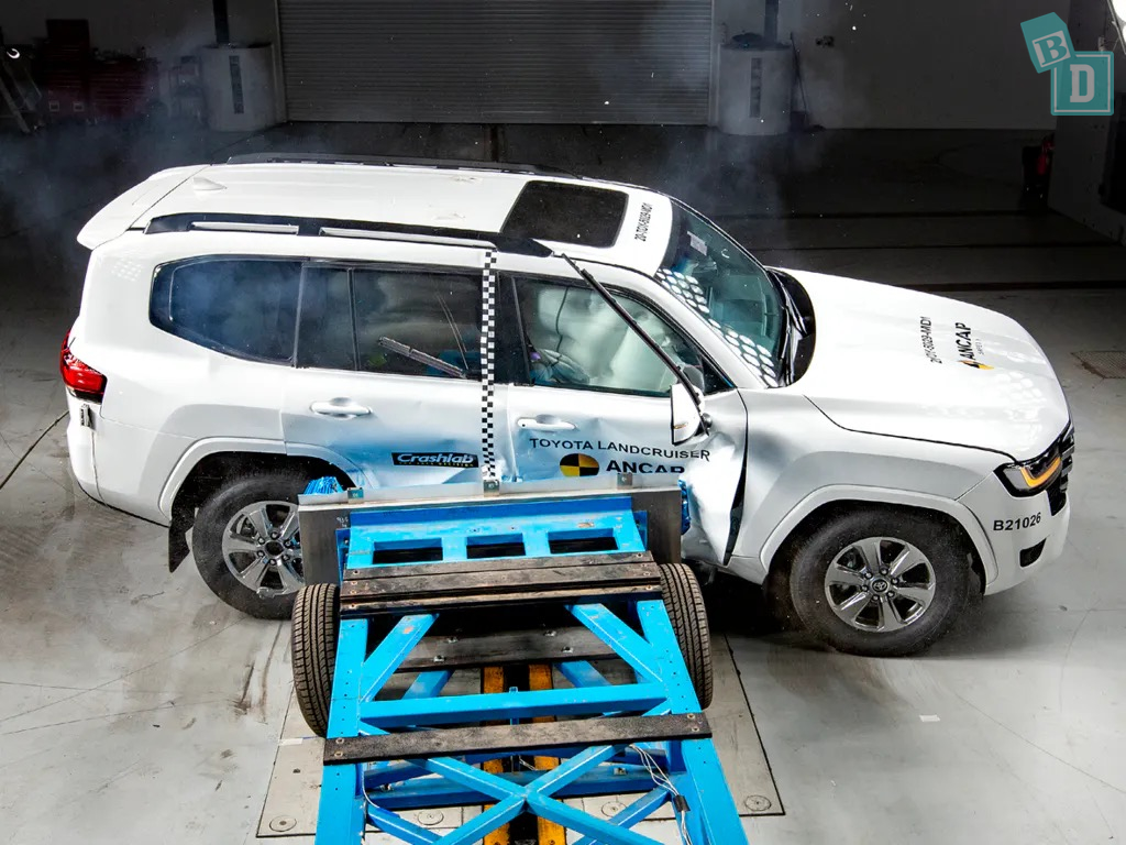 A white suv is being tested in a garage.