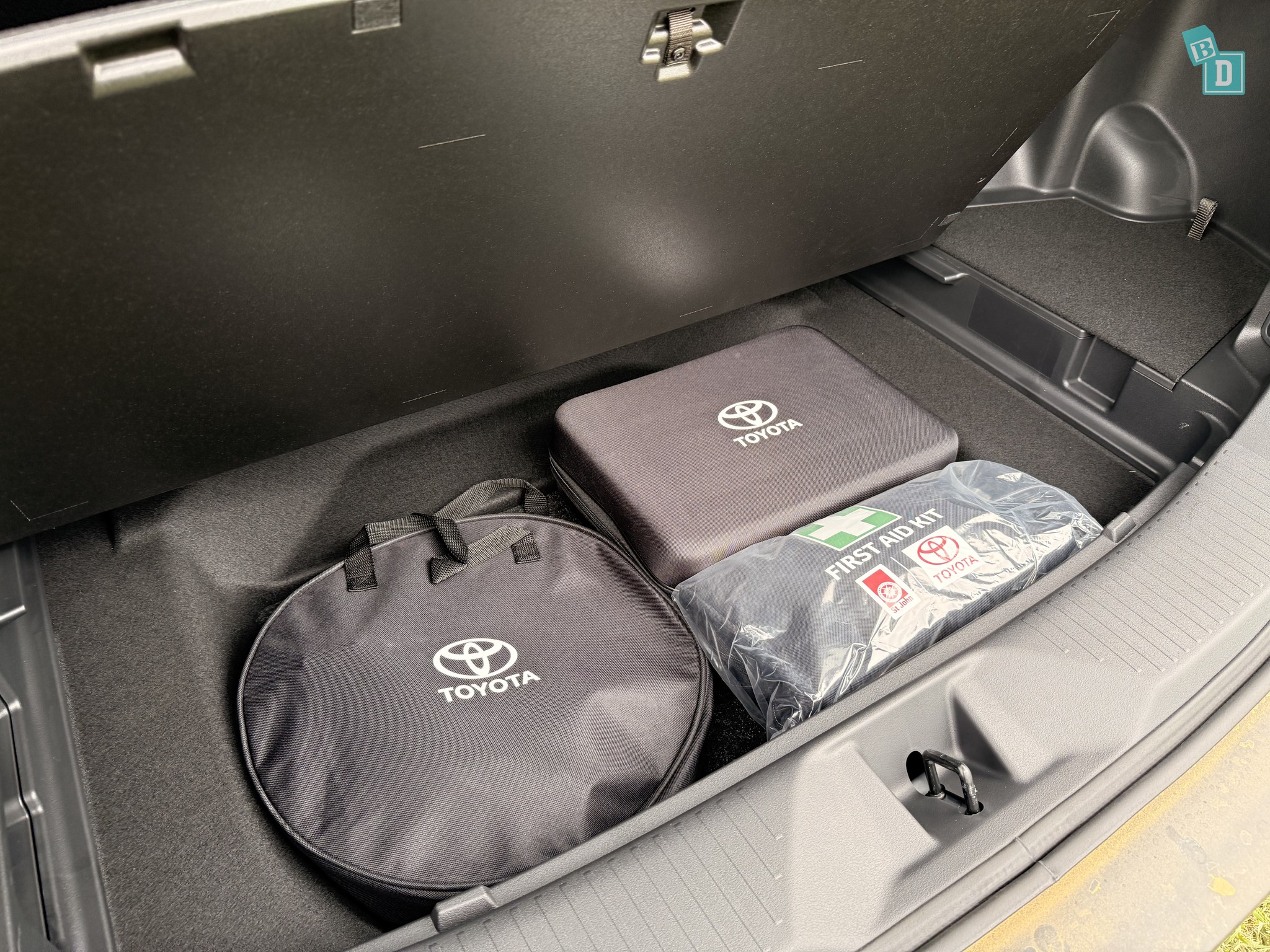2026 Toyota bZ4X Touring boot underfloor storage compartment with Toyota-branded tyre inflator bag, tool kit pouch and first aid kit